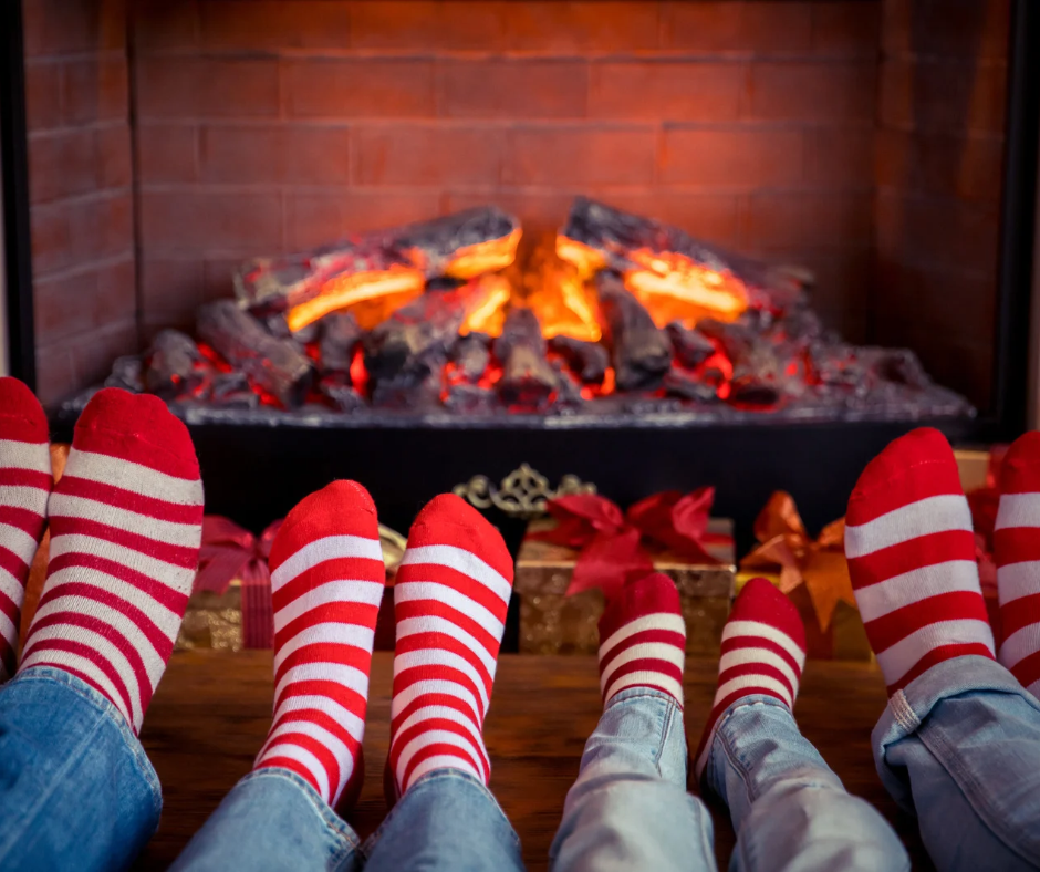 Family relaxing by the fireplace in festive holiday socks during winter break.